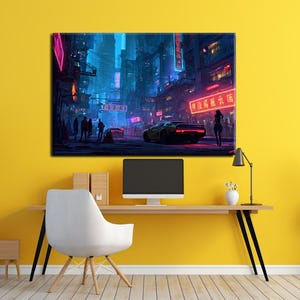 May include: A canvas print depicting a futuristic cityscape at night. Neon signs illuminate the streets, with a yellow sports car and silhouetted figures. The artwork is displayed on a yellow wall above a desk with a computer monitor and a white chair.