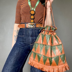 Puede incluir: Una taza de cerámica blanca con un asa negra y el texto "But First, Coffee" en un estilo manuscrito. La taza está sobre una superficie blanca. La taza mide aproximadamente 10 cm de alto.