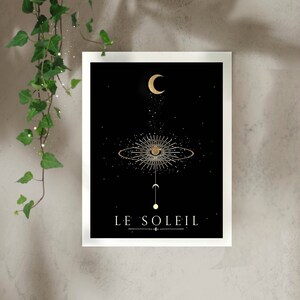 May include: A black and gold print with a stylized sun and moon design. The text "LE SOLEIL" is at the bottom of the print.