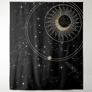 May include: A black tapestry featuring a gold crescent moon and sun with rays, enclosed within a circle and smaller circles. The background is a black night sky with white stars.