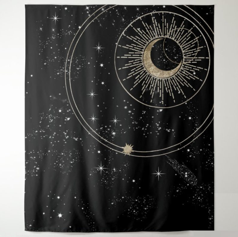 May include: A black tapestry featuring a gold crescent moon and sun with rays, enclosed within a circle and smaller circles. The background is a black night sky with white stars.