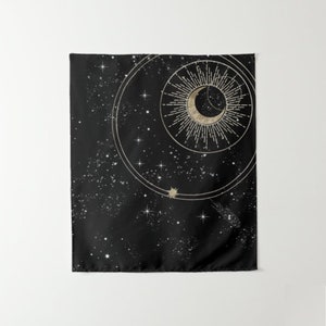 May include: A black tapestry featuring a gold crescent moon and sun design. The moon is encircled by a ring of stars, and the sun has a radiating pattern. The background is a dark blue with a scattering of white stars.