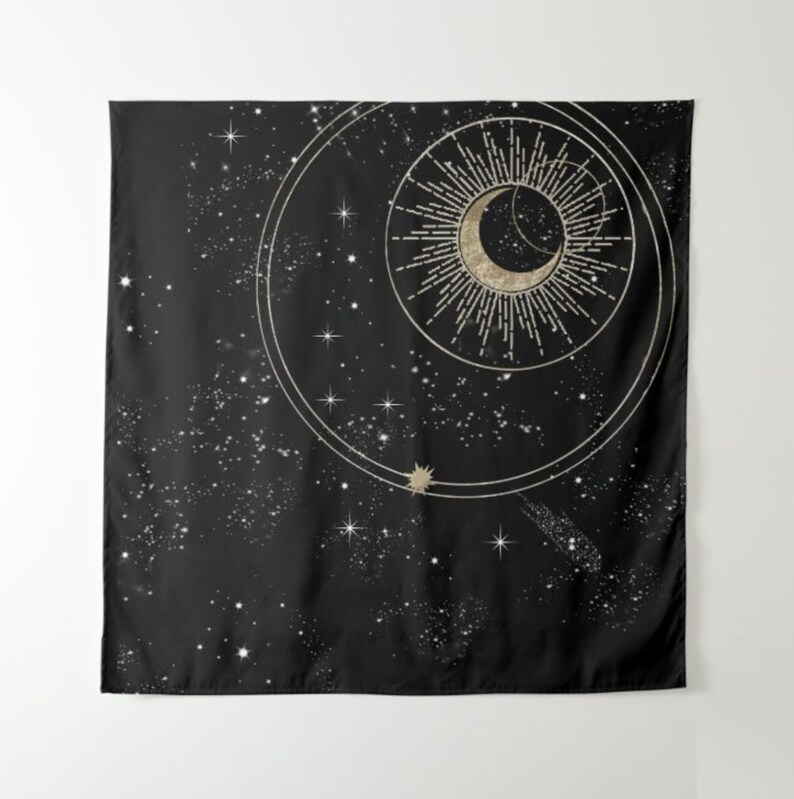 May include: A black tapestry featuring a gold crescent moon and sun design. The moon and sun are encircled by a ring of stars and a gold ring.