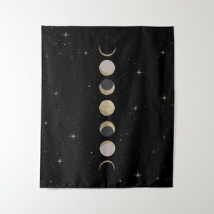 May include: A black tapestry with a white and gold moon phases design. The tapestry features a series of moons in different phases, from a crescent to a full moon, against a starry night background.