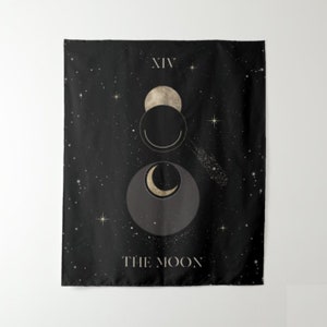 Puede incluir: Tapiz negro con un dise&ntilde;o de luna dorada y estrellas. El texto "XIV THE MOON" est&aacute; impreso en el tapiz.