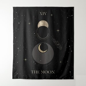 Puede incluir: Un tapiz negro con un dise&ntilde;o de luna y estrellas doradas y blancas. El texto "XIV THE MOON" est&aacute; impreso en la parte inferior del tapiz.