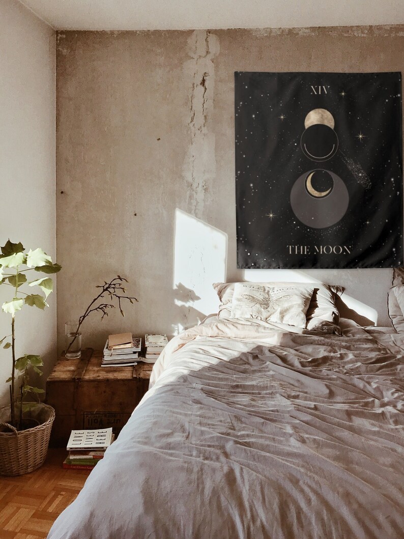 Puede incluir: Un tapiz negro con estrellas doradas y un dise&ntilde;o de luna creciente. El tapiz tiene el texto "XIV THE MOON".