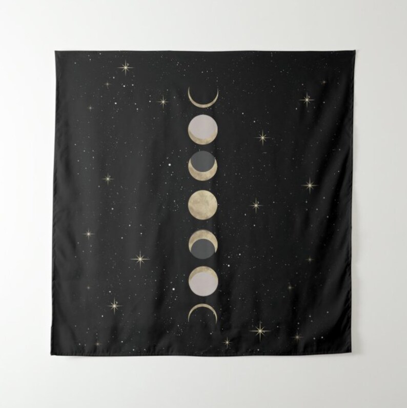 May include: A black tapestry with a white and gold moon phases design on a black background with white stars.