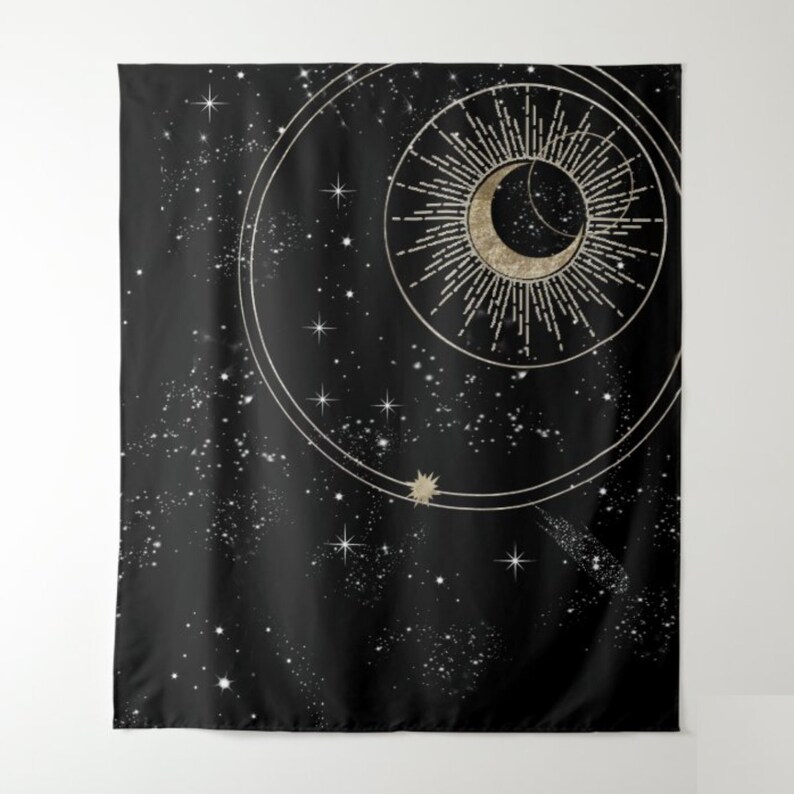 May include: A black tapestry featuring a gold crescent moon and sun design. The moon and sun are encircled by a circle of stars and a larger circle with a starburst pattern. The background is a dark blue with a scattering of white stars.
