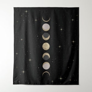 May include: A black tapestry with a gold and white moon phases design. The moon phases are arranged vertically in a row, with the new moon at the top and the full moon at the bottom. The background is a dark black with small white stars.