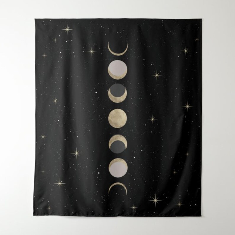 May include: A black tapestry with a gold and white moon phases design. The moon phases are arranged vertically in a row, with the new moon at the top and the full moon at the bottom. The background is a dark black with small white stars.