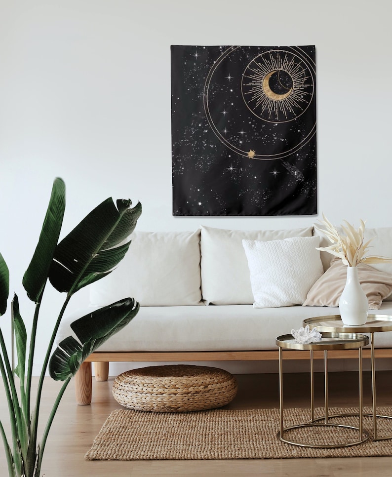 May include: A black tapestry featuring a gold crescent moon and sun design. The tapestry has a starry night sky background.