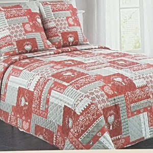 Peut inclure: Un ensemble de courtepointe patchwork rouge, blanc et gris avec deux taies d'oreiller assorties. La courtepointe présente un motif répétitif de carrés avec des motifs de cœurs et de fleurs. L'ensemble de literie est conçu pour un lit.