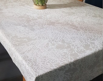 Toile enduite corail blanc sur un fond beige en 1.50 m de large.