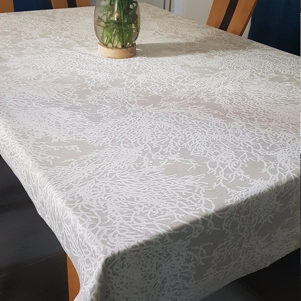 Toile enduite corail blanc sur un fond beige en 1.50 m de large.