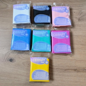 Peut inclure: Ensemble de trois mugs en céramique avec une finition mate et mouchetée. Les mugs sont de couleur crème, gris clair et gris foncé. Chaque mug a un design simple et moderne avec une anse arrondie.