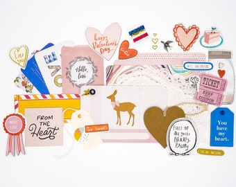May include: Assortment of Valentine's Day themed paper crafts, including hearts, tags, and a deer. The paper crafts are decorated with various colors, patterns, and text, such as "Hello, love", "From the Heart", and "You have my heart".