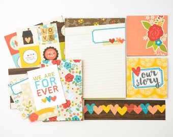 May include: A set of colorful scrapbook paper with floral and geometric patterns. The paper features phrases like "We are for ever", "Best ever", and "Our story".