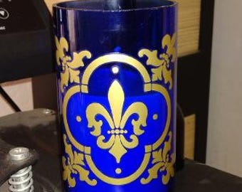 Cobalt blue jar candle with fleur-de-lis design.