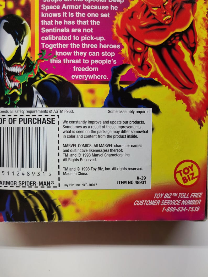 Puede incluir: Una caja roja, amarilla y azul con una imagen de una figura humana roja rodeada de llamas. La caja es para una figura de acci&oacute;n de Marvel Comics. El texto en la caja dice "Toy Biz" y "Armor Spider-Man".