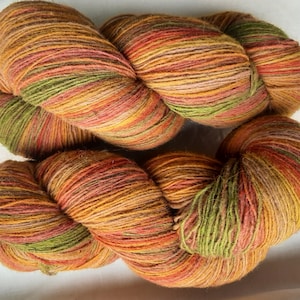Wollgarn zum Stricken. Hochwertiges mehrfarbiges orange, grün, grau, rot gestreiftes Garn. Natürliches Lanolin-Garn.