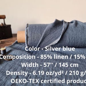 Puede incluir: Rollo de tela de lino azul plateado, de 145 cm de ancho, compuesto por 85% lino y 15% lana. Tambi&eacute;n se ven una plancha antigua, tijeras e hilo. Densidad de la tela: 210 g/m&sup2;.