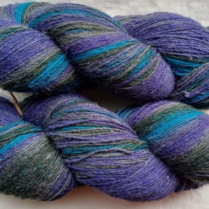 Wollgarn zum Stricken. Hochwertiges Multicolor lila, schwarz, gestreiftes Garn. Natürliches Lanolin-Garn.