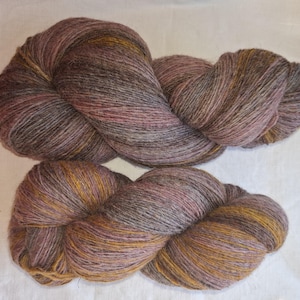 Wollgarn zum Stricken, Hochwertiges mehrfarbiges lila, Rost-Orange gestreiftes Wollgarn. Natürliches Lanolin-Garn.