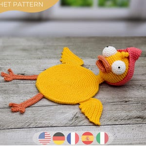 Puede incluir: Un juguete de pollo de ganchillo hecho a mano en amarillo, naranja y rosa. El pollo tiene ojos blancos grandes, patas y alas naranjas. El texto "CROCHET PATTERN" está en la parte superior de la imagen.