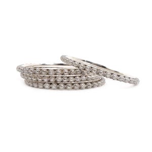 Op de afbeelding: Set van vier zilveren armbanden met een delicaat, parelmoer ontwerp.