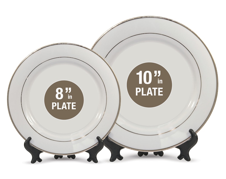 May include: Two white plates with gold trim, one 8 inches and the other 10 inches in diameter, are displayed on black stands. The plates have a simple, elegant design, suitable for various occasions.