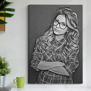 Pu&ograve; includere: Stampa di un ritratto in bianco e nero di una persona con occhiali e una camicia a quadri. La persona ha lunghi capelli ondulati e guarda l'osservatore con le braccia incrociate. L'opera d'arte &egrave; esposta su una parete.