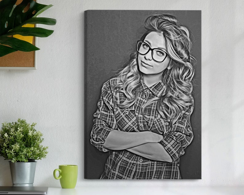 Pu&ograve; includere: Stampa di un ritratto in bianco e nero di una persona con occhiali e una camicia a quadri. La persona ha lunghi capelli ondulati e guarda l'osservatore con le braccia incrociate. L'opera d'arte &egrave; esposta su una parete.