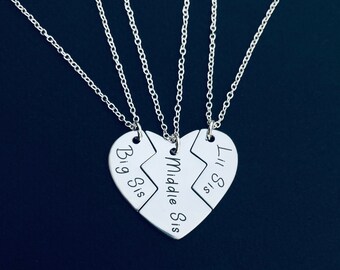 May include: Three silver necklaces with heart-shaped pendants that say "Big Sis", "Middle Sis", and "Lil Sis".