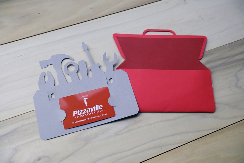May include: A gray card shaped like a toolbox with tool silhouettes, holding a red gift card. A red toolbox-shaped card is next to it. The gift card reads "Pizzaville" and "Stone Baked Pizza".