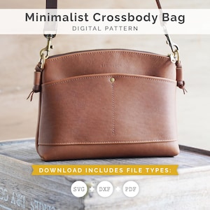 May include: A brown leather crossbody bag with a front pocket and a zip closure. The bag has a long strap and gold-coloured hardware. The text "Minimalist Crossbody Bag" and "DIGITAL PATTERN" are displayed at the top. The bottom text reads "DOWNLOAD INCLUDES FILE TYPES:" with SVG, DXF, and PDF icons.