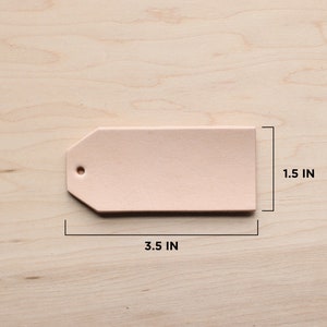 May include: A light pink leather tag with a hole in the top. The tag is 3.5 inches wide and 1.5 inches tall.