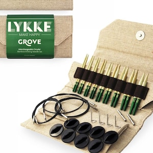 May include: A set of interchangeable circular knitting needles in a beige canvas case. The case has a flap with the text "LYKKE MAKE HAPPY GROVE Interchangeable Circular Bamboo Knitting Needle Set". The needles are made of bamboo and have green tips. The set includes 8 pairs of needles, 8 cable cords, 8 end caps, and 3 stitch markers.