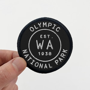 May include: Black and white embroidered patch with the text "Olympic National Park Est. 1938 WA" in a circle.