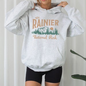May include: A gray hooded sweatshirt with a graphic print of a mountain range and the text "Mt. Rainier National Park".