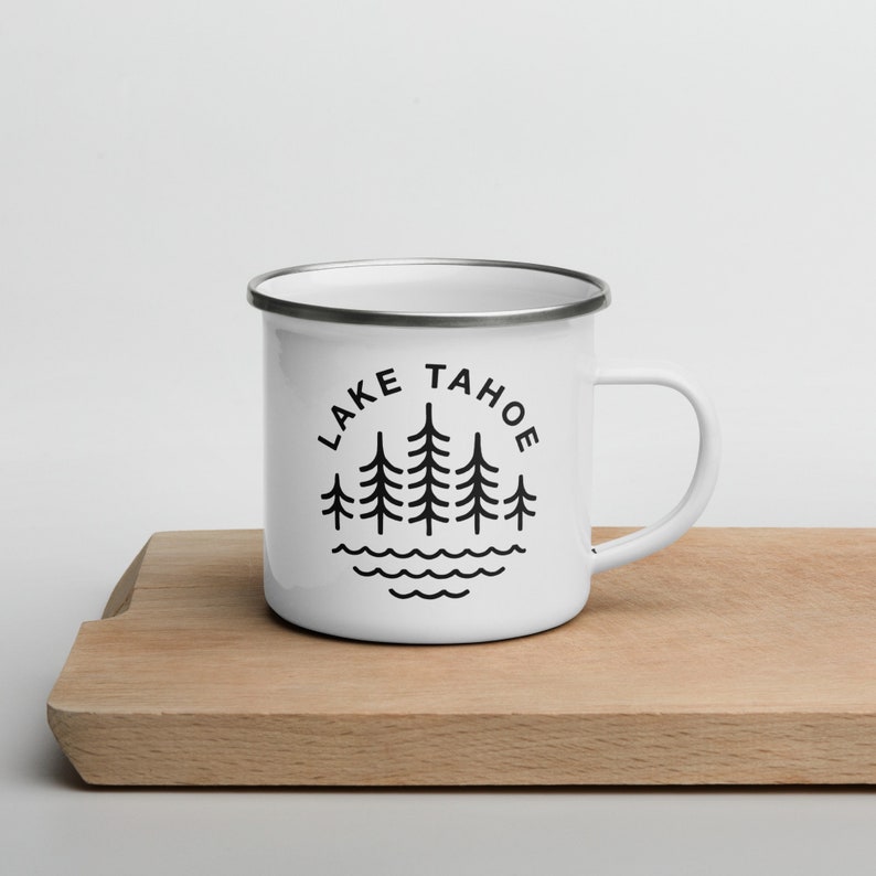 May include: White enamel camping mug with a black silhouette of pine trees and the text "LAKE TAHOE" in a circle.