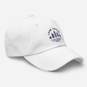 May include: White baseball cap with a navy blue embroidered design of pine trees and the text "LAKE TAHOE" in a circle.