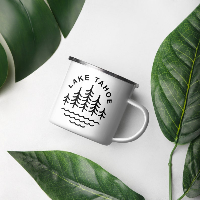 May include: White enamel camping mug with a black silhouette of pine trees and the text "LAKE TAHOE" in a circle.