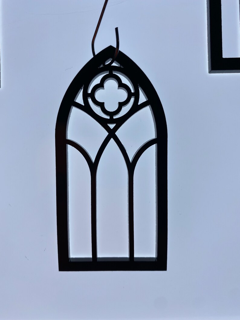 May include: Black wooden cutout of a gothic arch window with a quatrefoil design.