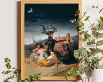 May include: A framed art print depicting Francisco Goya's Witches' Sabbath, featuring a large central goat figure surrounded by a group of seated people in a dark, moonlit landscape with a crescent moon in the night sky above.