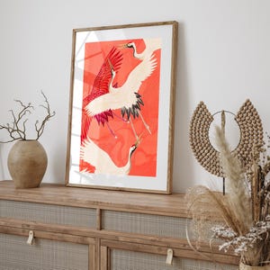 Red and white Japanese cranes in flight illustrated in a traditional Asian art style on a vibrant red background. Framed or unframed wall art.