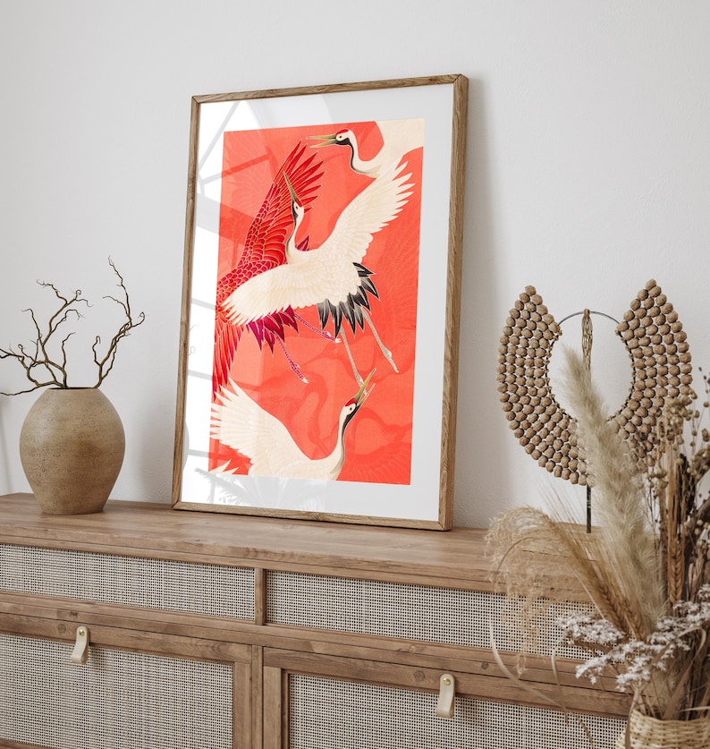 Red and white Japanese cranes in flight illustrated in a traditional Asian art style on a vibrant red background. Framed or unframed wall art.