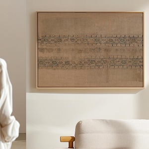 Könnte beinhalten: Ein gerahmtes Kunstwerk mit beigem Hintergrund und einem dekorativen Muster in Dunkelgrau. Das Kunstwerk ist rechteckig und in einem hellbraunen Holzrahmen montiert. Das Muster besteht aus sich wiederholenden geometrischen Formen.