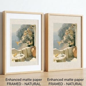 Set of 3 Amalfi Coast fine art prints side by side in natural wood box frames on a light oak shelf — left frame includes white mat border, right frame without mat, both featuring Positano balcony oil painting print on enhanced matte paper
