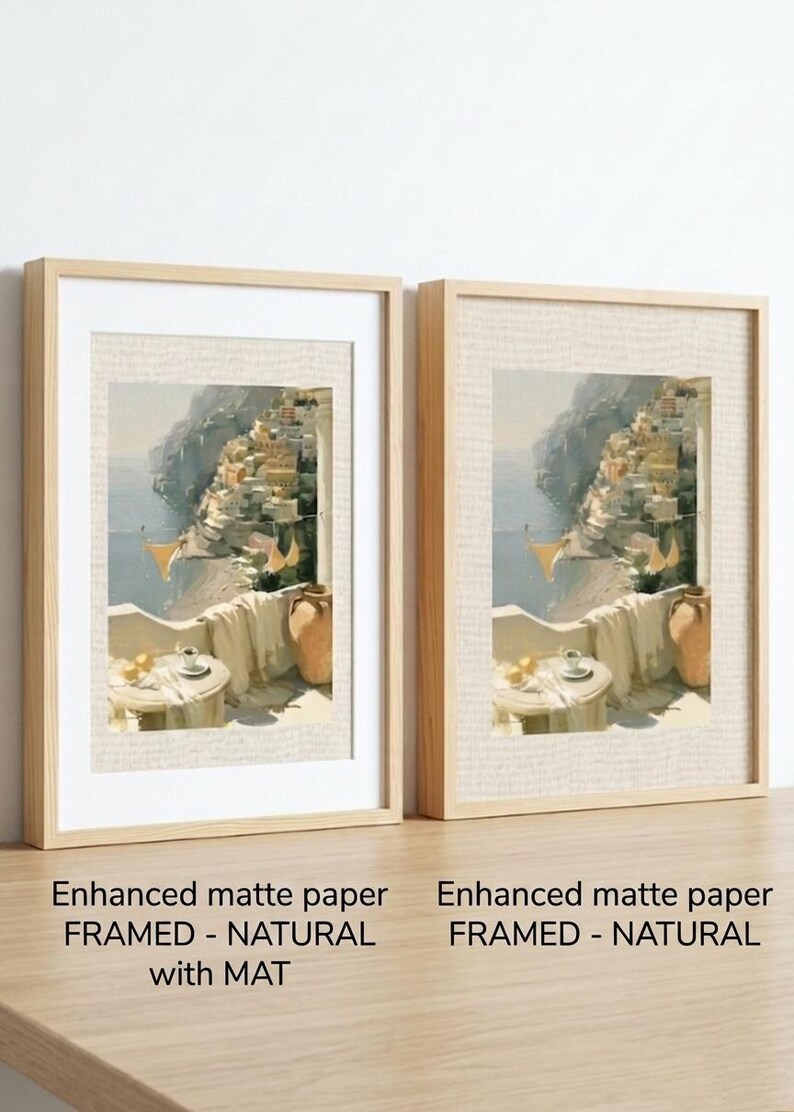 Set of 3 Amalfi Coast fine art prints side by side in natural wood box frames on a light oak shelf — left frame includes white mat border, right frame without mat, both featuring Positano balcony oil painting print on enhanced matte paper